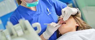 happy female dentist checking patient girl teeth up at dental clinic office