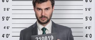 Mugshot of man in suit at police station - prisoner identification concep