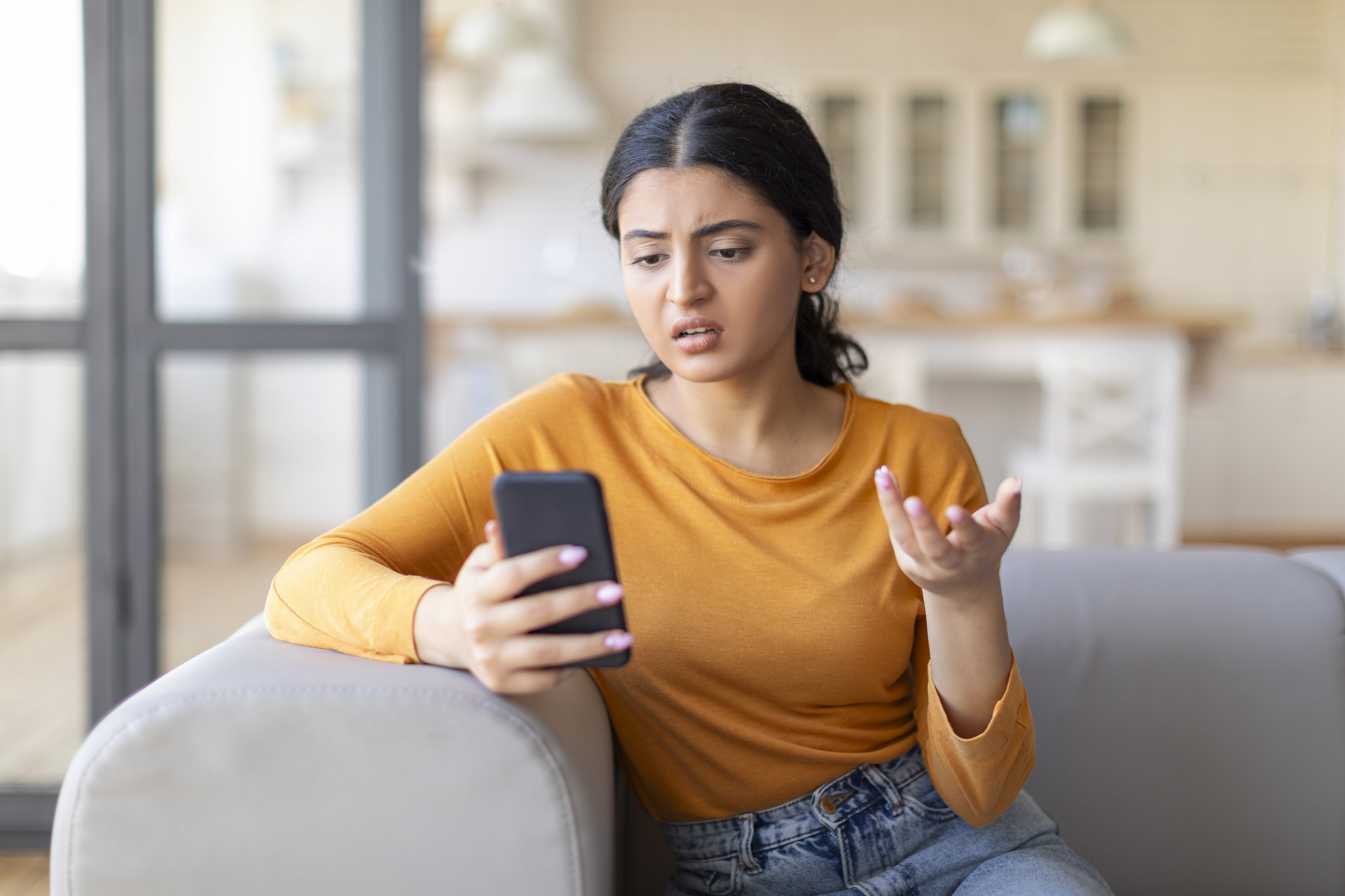 Problem With Phone. Displeased Indian Woman Using Smartphone At Home