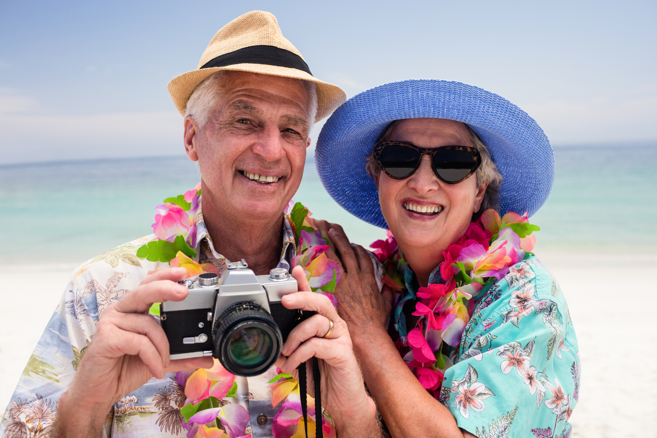 Senior couple clicking a photo with camera on the beach