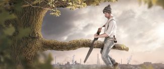 A man is sitting on a branch he is about to cut off. The background shows an industrial area which is polluting the surroundings. Thus the image conveys a secondary meaning towards environmental pollution.