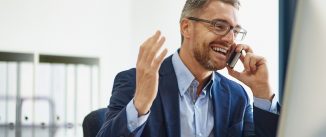 Mature man doing business on the phone in front of his computer