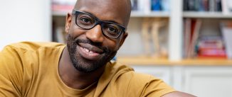 Portrait of a happy African American man at home and looking at the camera smiling - domestic life concepts