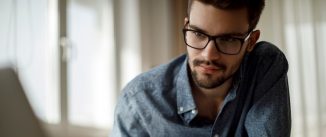 Young man with glasses working at a computer