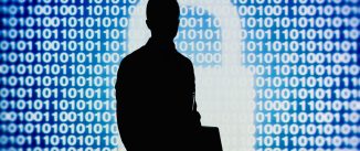 Man standing and holding laptop with code and white figure of a padlock behind him