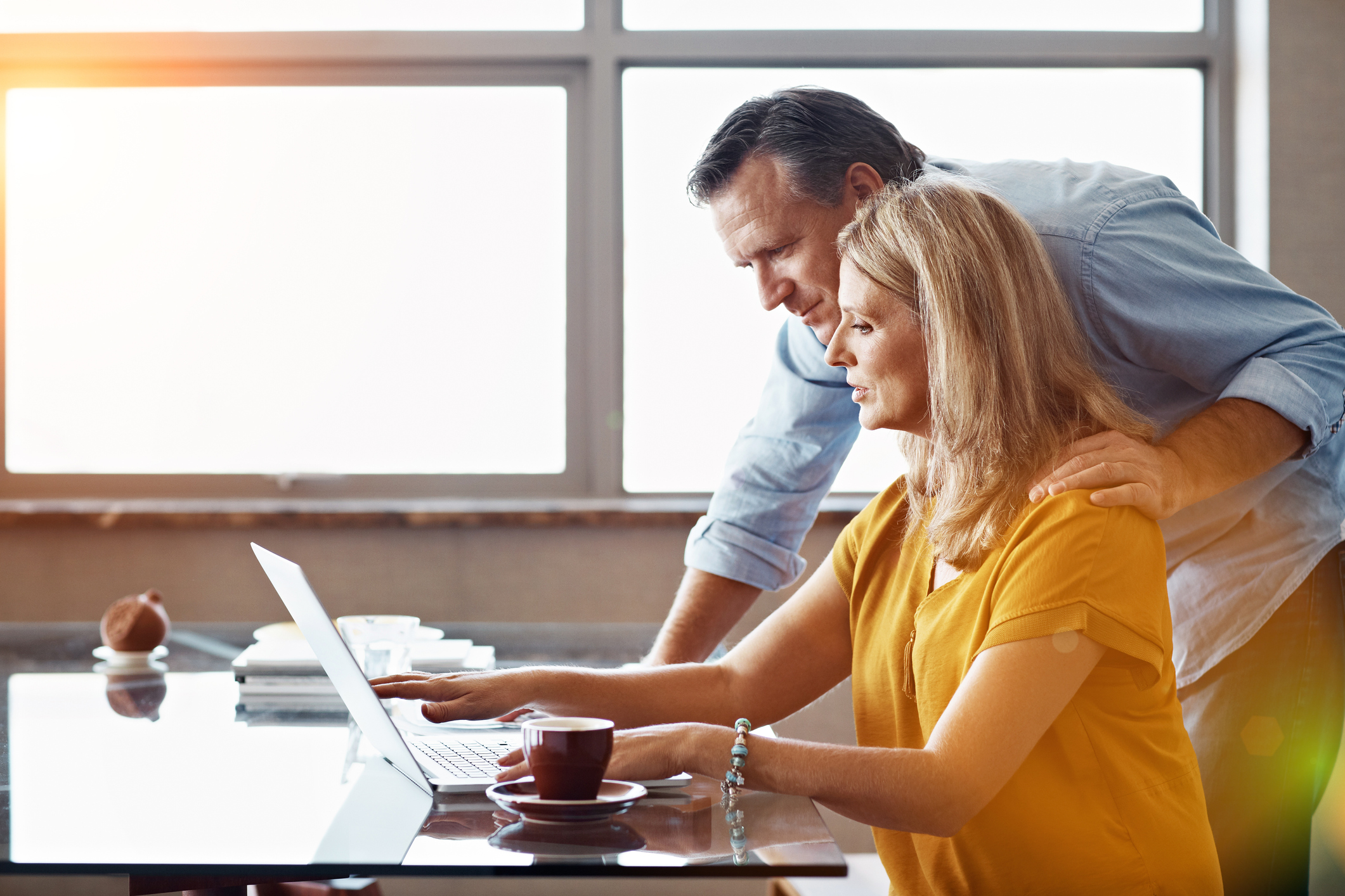 Shot of a mature couple sitting at their dining room table doing online banking using a laptop