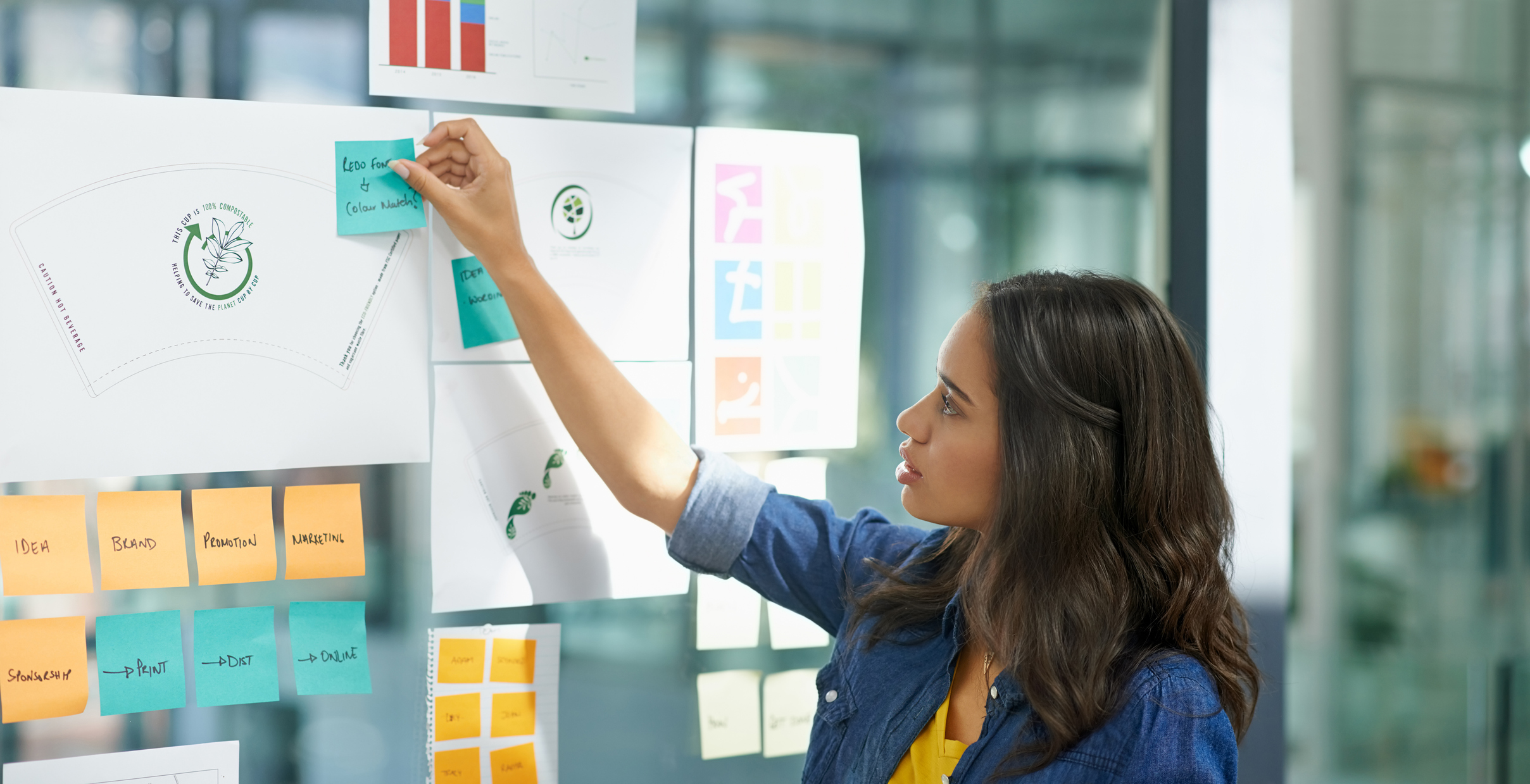 Cropped shot of a young woman brainstorming with sticky notes at work