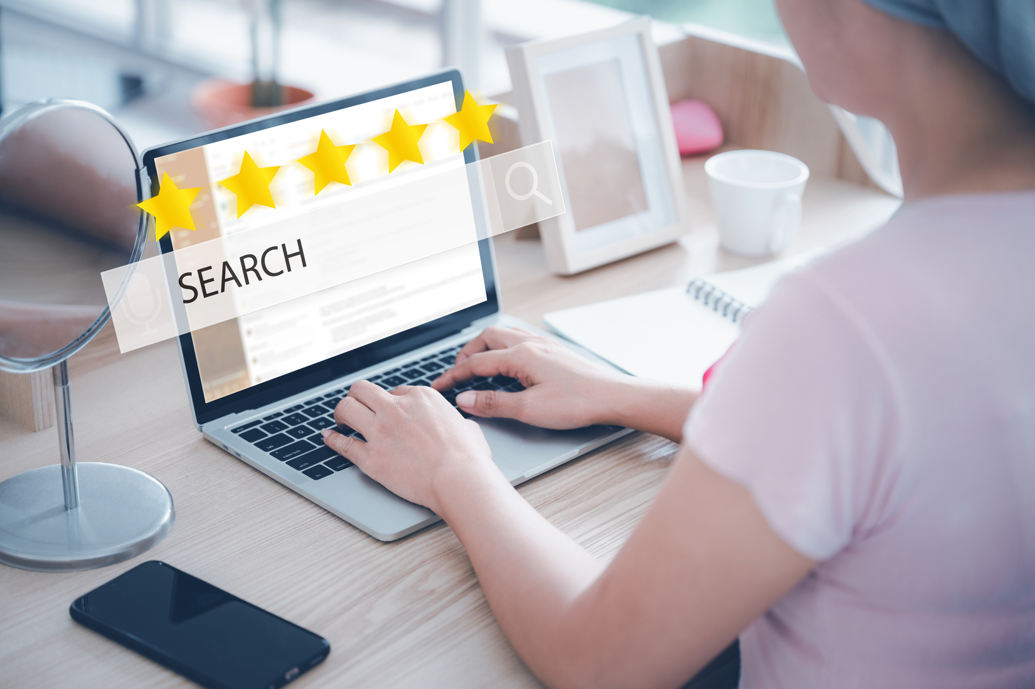 Young Asian woman wearing a hijab uses her laptop to search for 5 stars through the internet at her desk. Concept of online web use