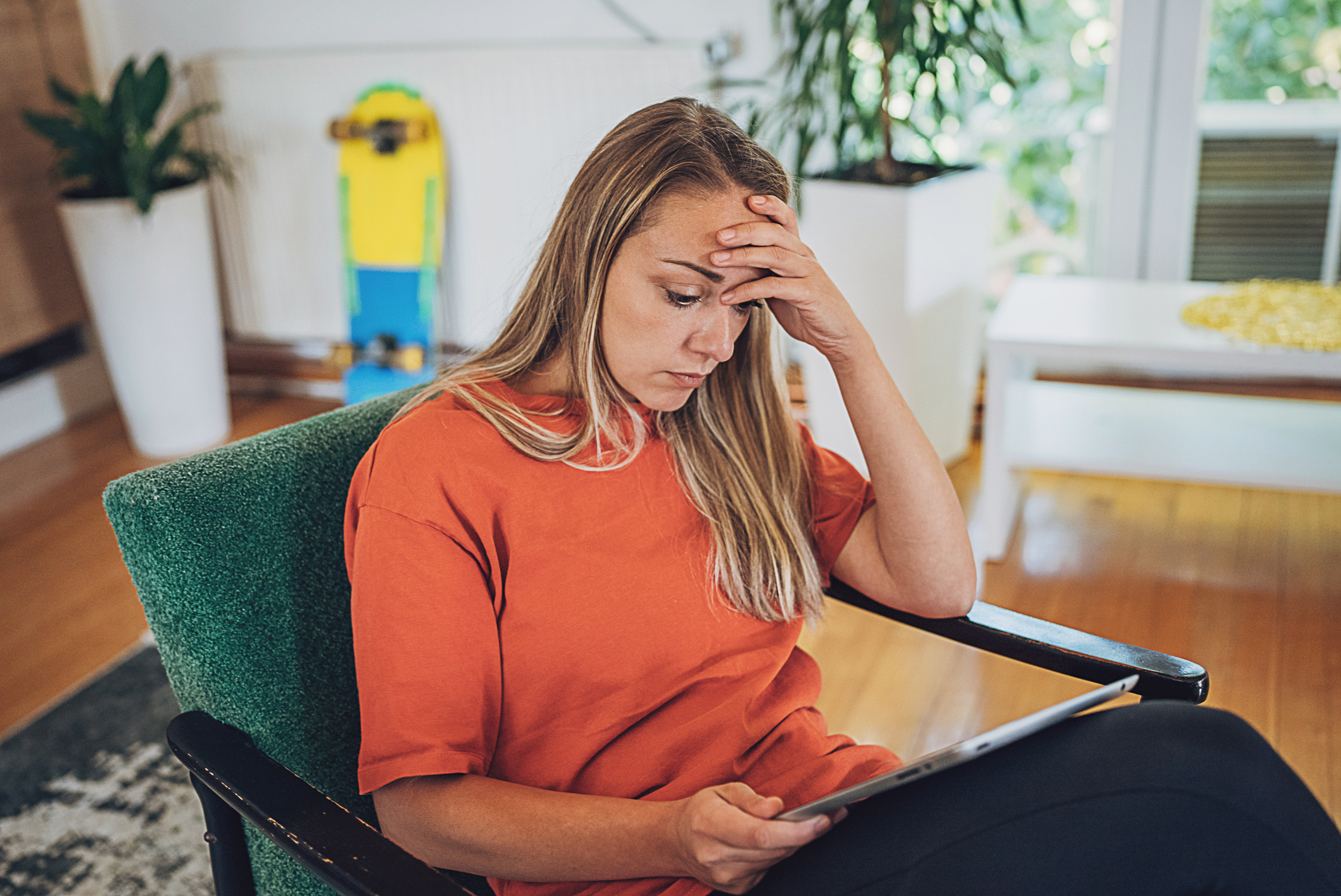 Young woman experiencing online fraud on digital tablet