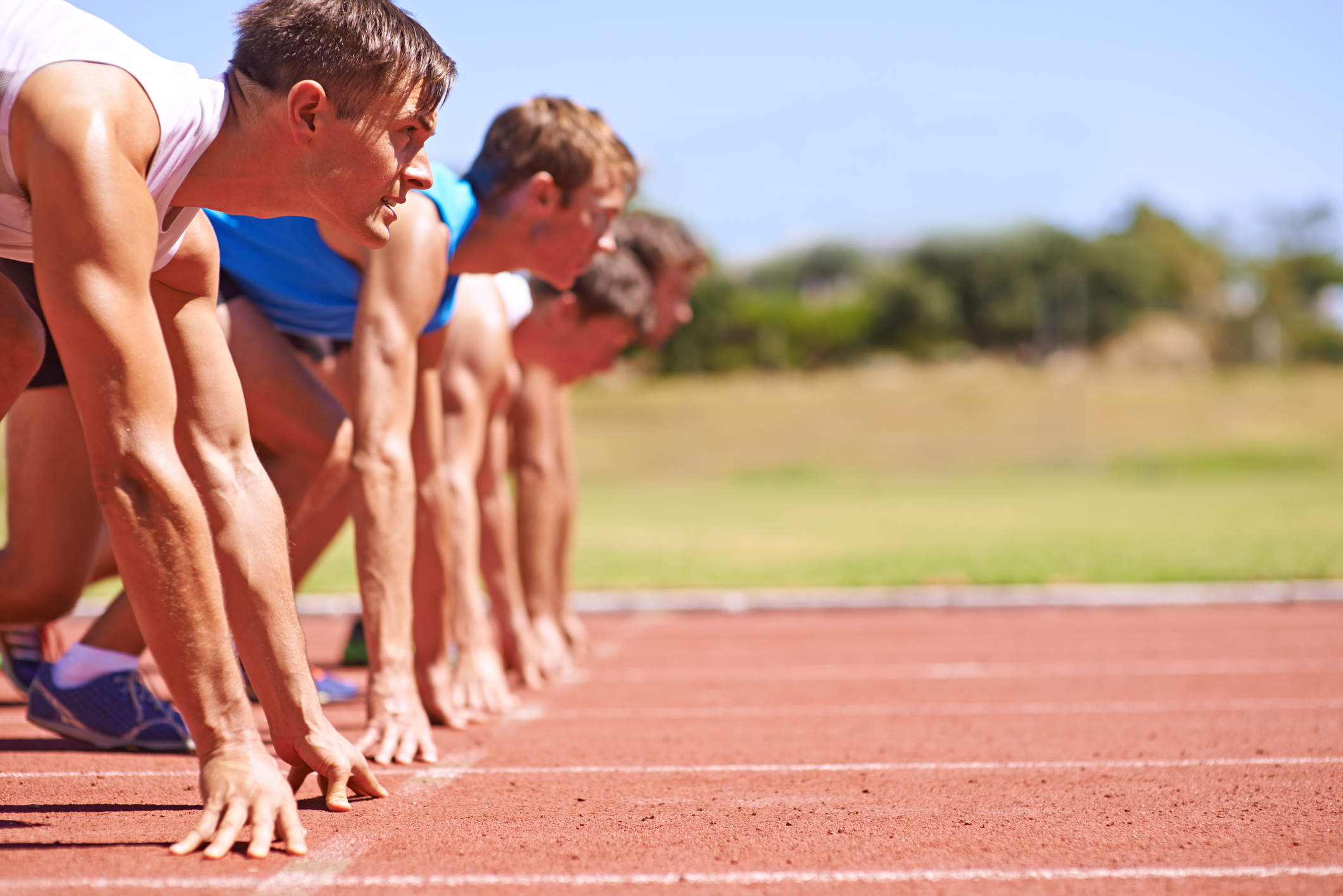 Cropped side view of a group of athletes at the start of a track race